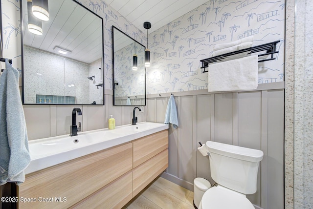 bathroom featuring double vanity, toilet, wooden ceiling, and a sink
