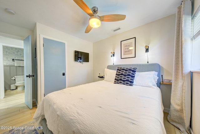 bedroom featuring a ceiling fan, visible vents, ensuite bathroom, and light wood-type flooring