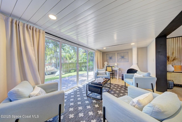 living area with recessed lighting, floor to ceiling windows, and wood finished floors