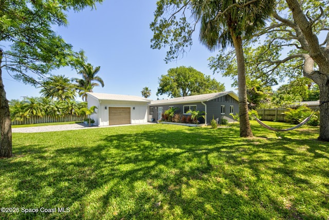 ranch-style house featuring board and batten siding, driveway, a front yard, fence, and an attached garage