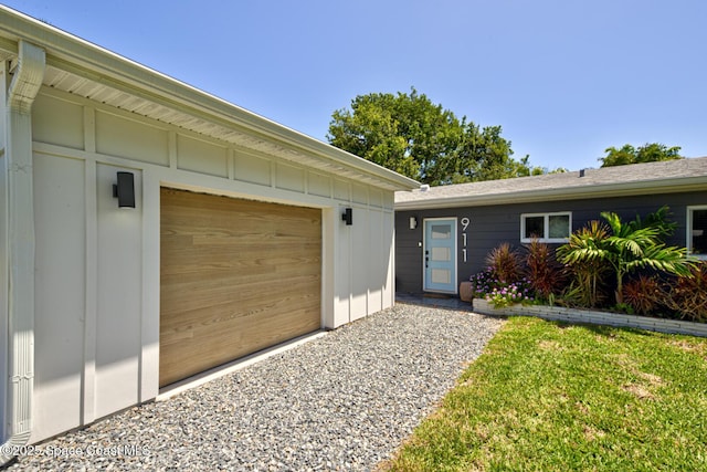property entrance featuring board and batten siding, an attached garage, and driveway