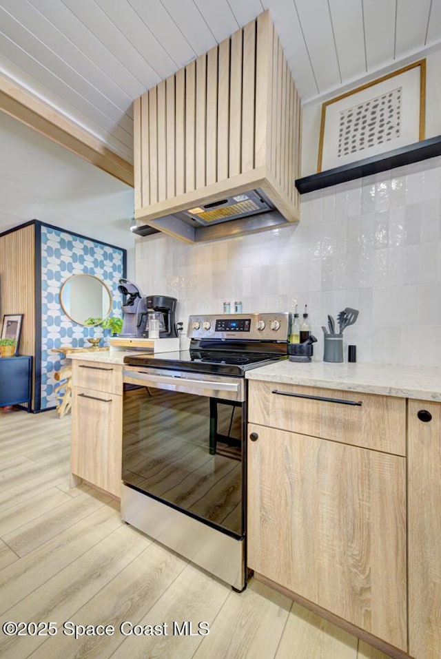 kitchen featuring stainless steel electric stove, light brown cabinets, and light wood-type flooring
