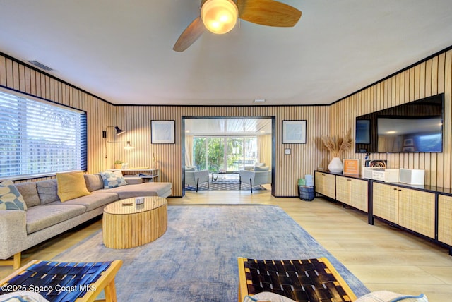 living area with a ceiling fan, wood finished floors, and visible vents
