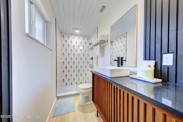 full bath featuring visible vents, vanity, wood finished floors, toilet, and a stall shower