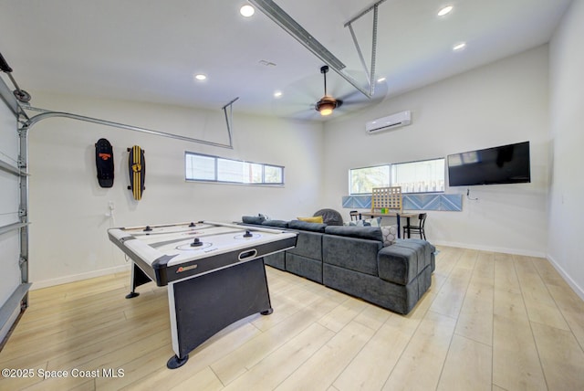 game room featuring light wood finished floors, a wall unit AC, a ceiling fan, and recessed lighting
