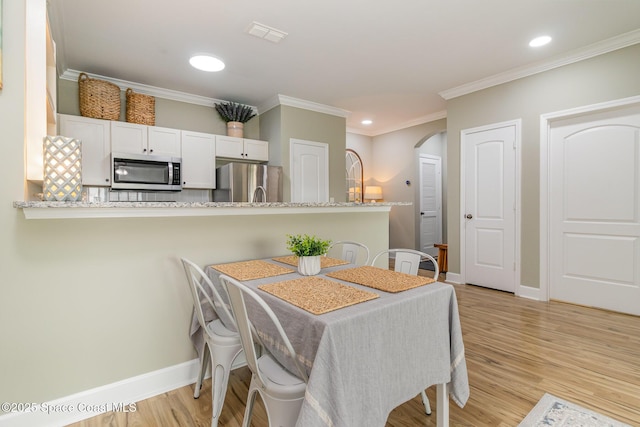 6461 Borasco Dr Unit 3804, Melbourne, FL 32940 - dining room featuring arched walkways, light wood finished floors, crown molding, and recessed lighting