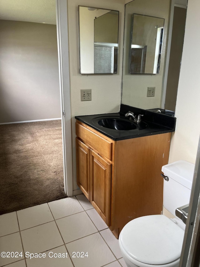 bathroom with toilet, tile patterned floors, and vanity