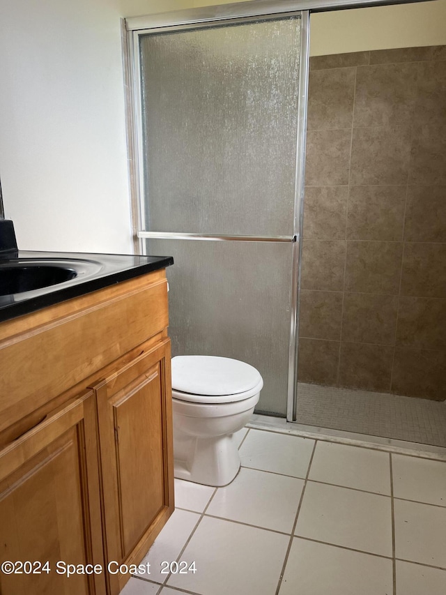 bathroom with vanity, toilet, tile patterned flooring, and a shower stall
