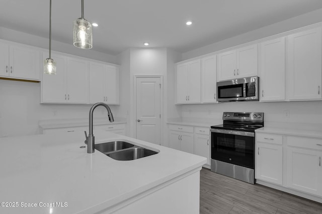 3155 Viridian Cir, Melbourne, FL 32904 - kitchen with light countertops, hanging light fixtures, a sink, white cabinets, and appliances with stainless steel finishes