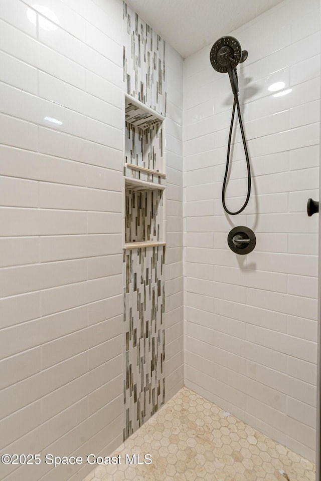 bathroom featuring tile patterned flooring and tiled shower