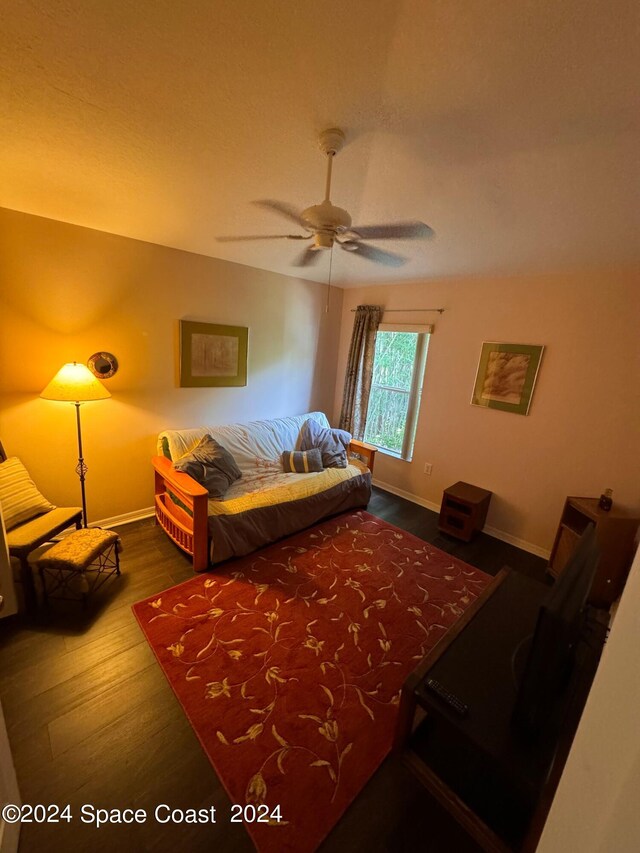bedroom featuring baseboards, wood finished floors, and a ceiling fan
