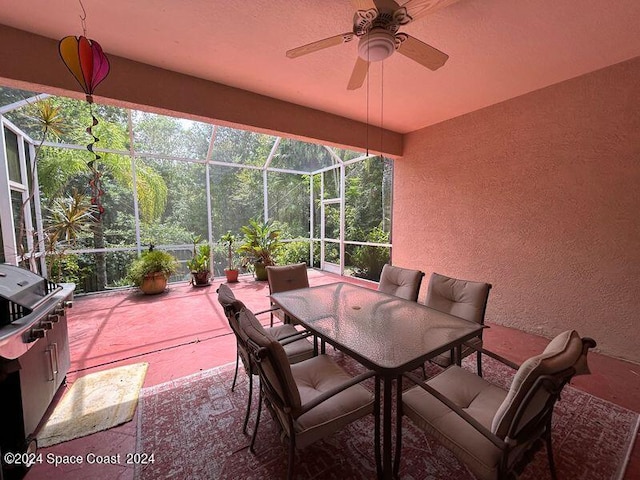 view of patio / terrace featuring outdoor dining space, a lanai, and ceiling fan