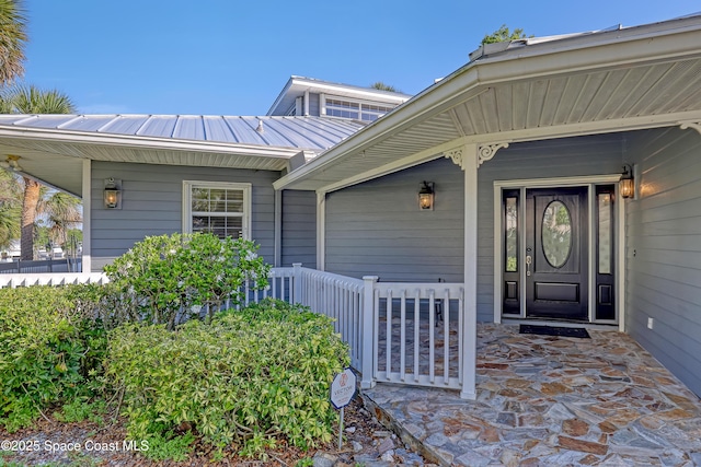 property entrance featuring a porch and metal roof