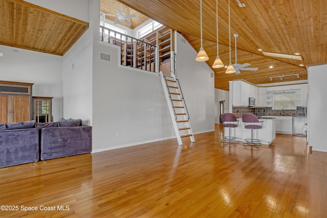 living area featuring a ceiling fan, wooden ceiling, stairway, high vaulted ceiling, and light wood-style flooring