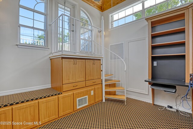 stairs with plenty of natural light and carpet