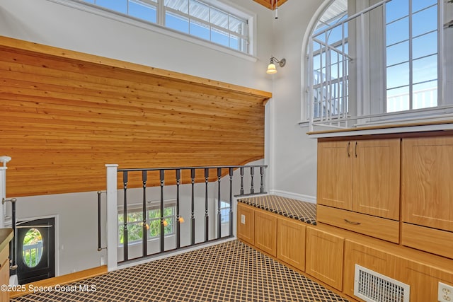 staircase with a towering ceiling and carpet flooring