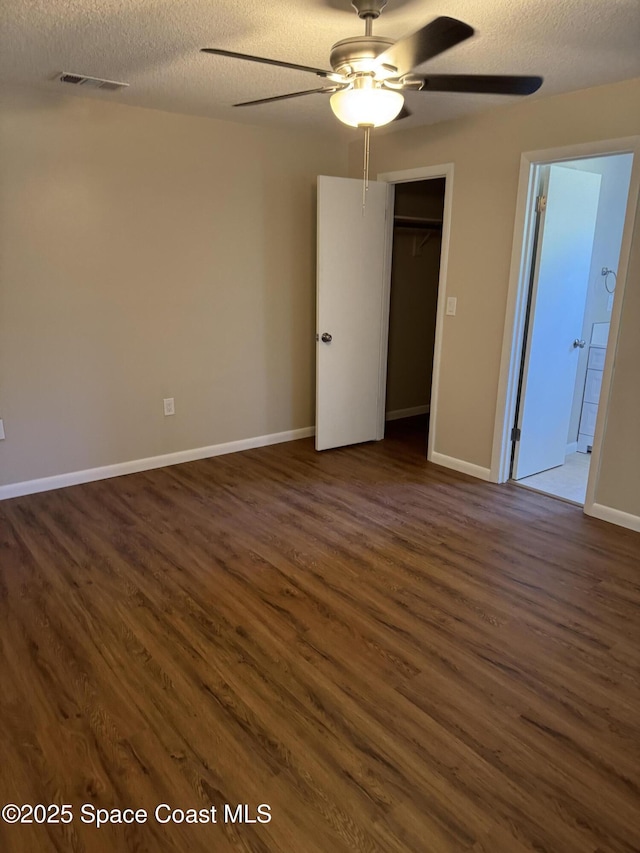 spare room featuring a ceiling fan, dark wood finished floors, a textured ceiling, and visible vents