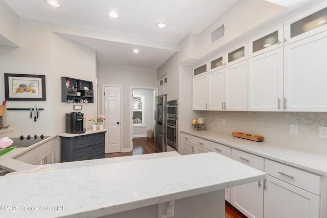 kitchen with white cabinets, dark wood-style flooring, and visible vents
