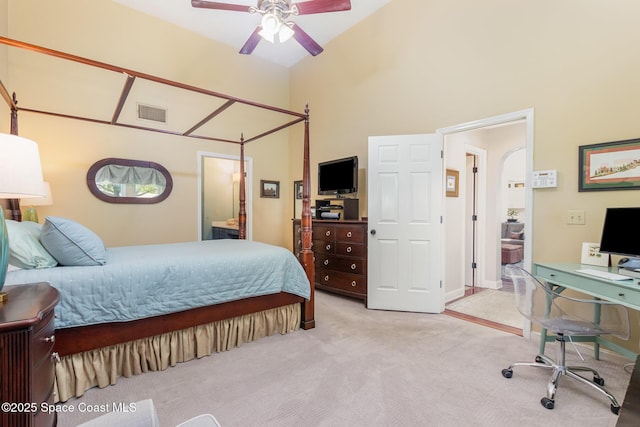 bedroom featuring connected bathroom, light colored carpet, arched walkways, high vaulted ceiling, and visible vents