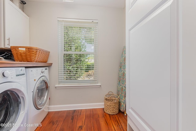 laundry area with baseboards, cabinet space, wood finished floors, and washer and dryer