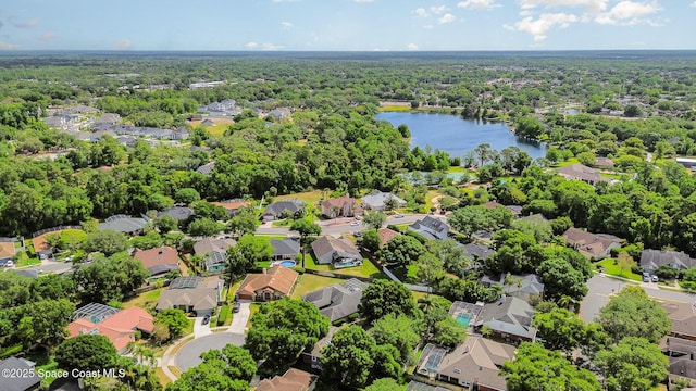 drone / aerial view featuring a residential view, a water view, and a wooded view