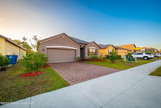 487 Old Country Rd SE, Palm Bay, FL 32909 - ranch-style home with a front lawn, decorative driveway, a garage, and stucco siding