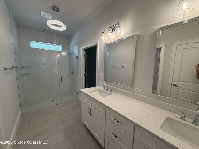 bathroom with a shower stall, double vanity, visible vents, and a sink
