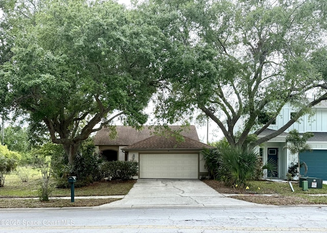 ranch-style home with an attached garage, stucco siding, driveway, and roof with shingles