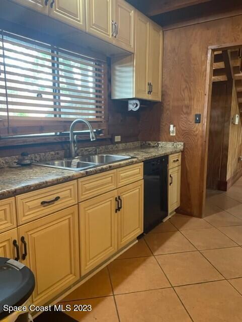 kitchen with black dishwasher, a sink, and light tile patterned floors