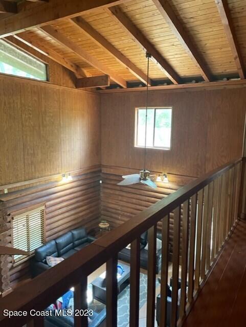 staircase with wooden ceiling, beam ceiling, and hardwood / wood-style flooring