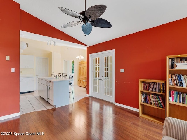 344 Concha Dr, Sebastian, FL 32958 - interior space with baseboards, french doors, light wood-style floors, lofted ceiling, and ceiling fan with notable chandelier