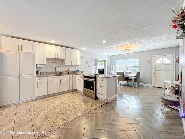 1760 Tee Dee Ln, Titusville, FL 32780 - kitchen featuring decorative backsplash, a peninsula, white cabinetry, a sink, and electric range