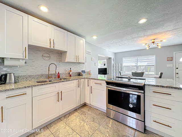 1760 Tee Dee Ln, Titusville, FL 32780 - kitchen featuring white cabinets, a sink, decorative backsplash, and stainless steel electric stove