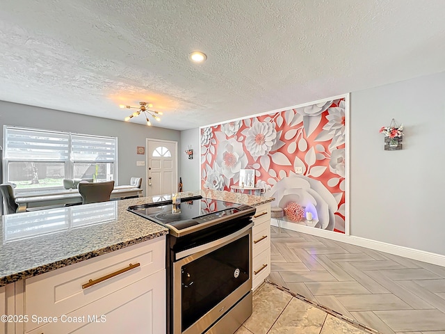 1760 Tee Dee Ln, Titusville, FL 32780 - kitchen featuring a textured ceiling, electric range, stone countertops, white cabinets, and a notable chandelier