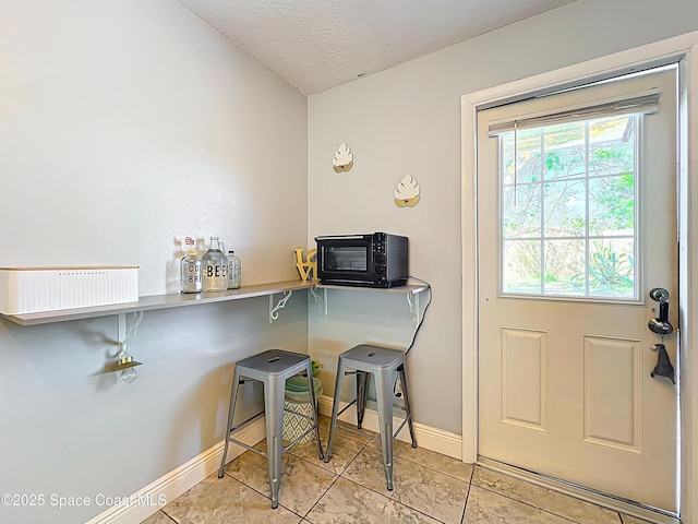 1760 Tee Dee Ln, Titusville, FL 32780 - interior space featuring light tile patterned floors, a textured ceiling, baseboards, and a toaster