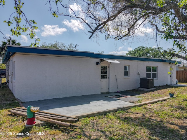 1760 Tee Dee Ln, Titusville, FL 32780 - rear view of house featuring central air condition unit, stucco siding, and a patio area