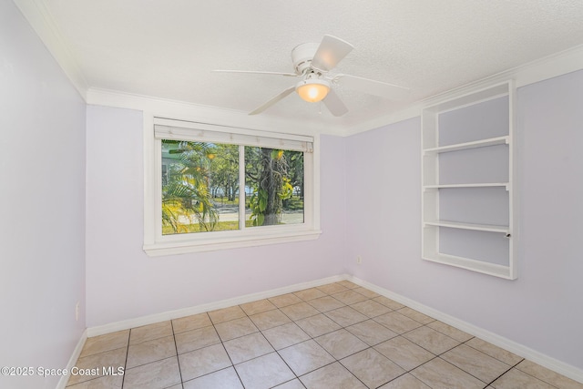 spare room with built in shelves, a textured ceiling, baseboards, ceiling fan, and ornamental molding