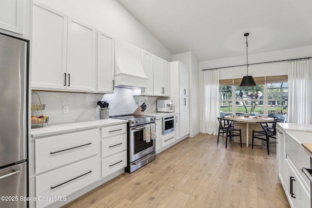 2702 Barrow Dr, Merritt Island, FL 32952 - kitchen with white cabinetry, light wood finished floors, backsplash, and appliances with stainless steel finishes