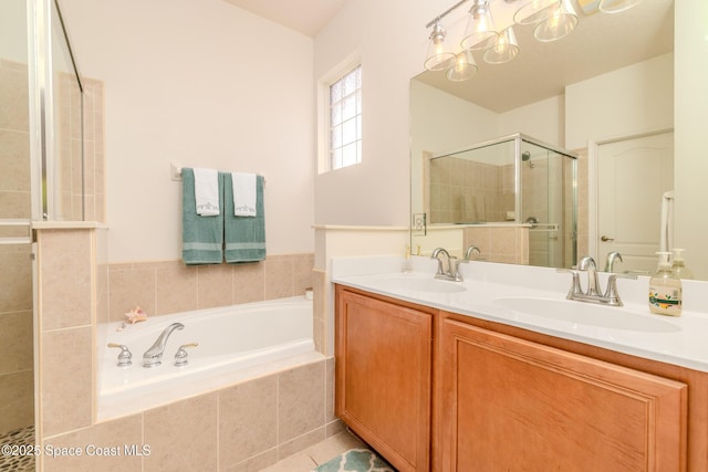 full bath with double vanity, a garden tub, a sink, and a stall shower