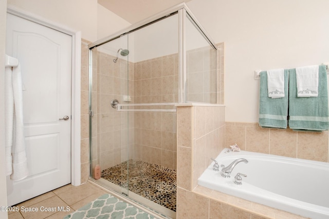 full bath featuring tile patterned floors, a stall shower, and a garden tub