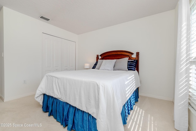 carpeted bedroom featuring a closet, baseboards, and visible vents