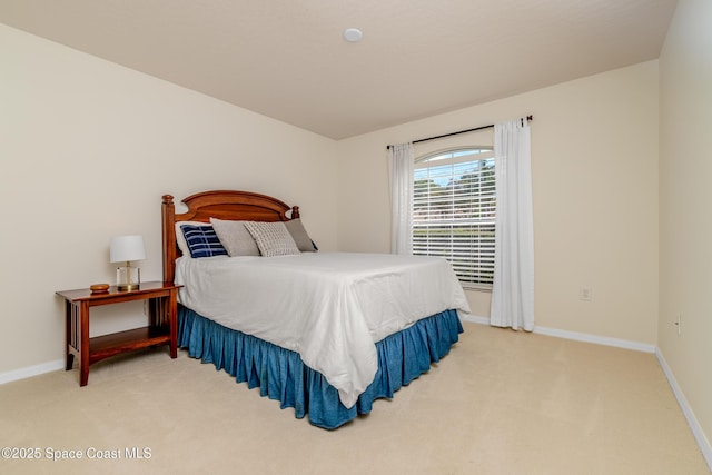bedroom with baseboards and light carpet