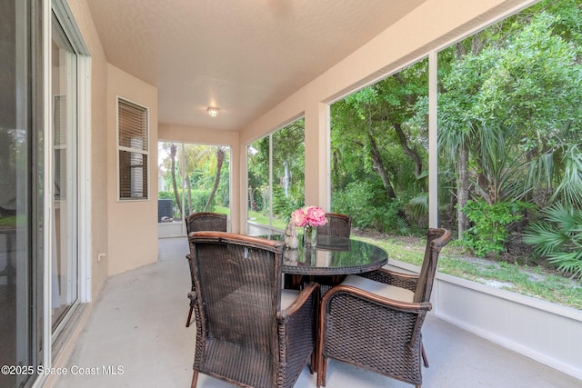 sunroom / solarium featuring outdoor dining space