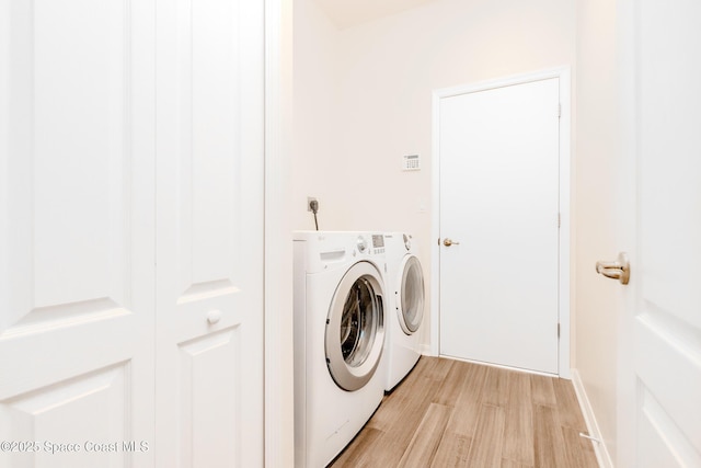 washroom featuring light wood-style flooring, baseboards, independent washer and dryer, and laundry area