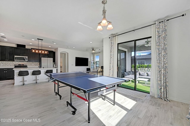 playroom with a ceiling fan, arched walkways, light wood finished floors, and visible vents