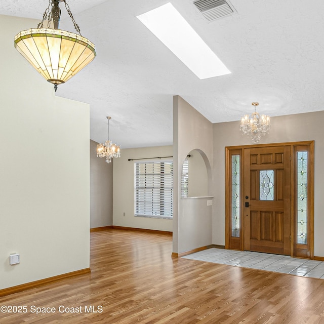 523 Hidden Hollow Dr, Merritt Island, FL 32952 - foyer with wood finished floors, a notable chandelier, a textured ceiling, and visible vents