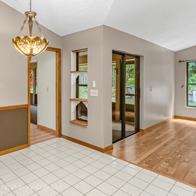 523 Hidden Hollow Dr, Merritt Island, FL 32952 - empty room with baseboards, light wood-style floors, lofted ceiling, and a textured ceiling