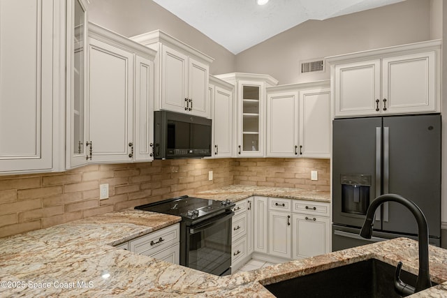 523 Hidden Hollow Dr, Merritt Island, FL 32952 - kitchen featuring vaulted ceiling, light stone counters, a sink, visible vents, and black appliances
