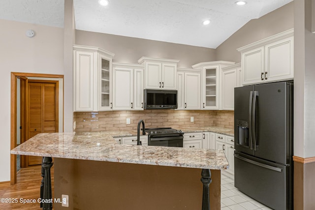 523 Hidden Hollow Dr, Merritt Island, FL 32952 - kitchen with a peninsula, tasteful backsplash, black appliances, and vaulted ceiling