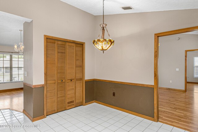 523 Hidden Hollow Dr, Merritt Island, FL 32952 - dining space featuring vaulted ceiling, light wood-type flooring, an inviting chandelier, a textured ceiling, and visible vents